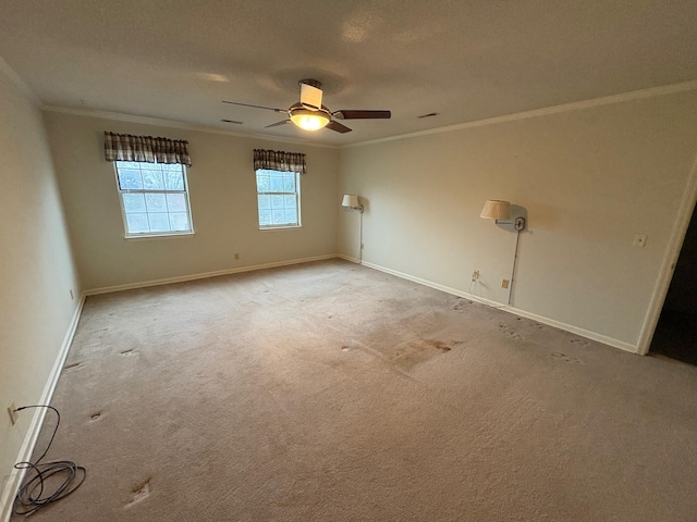 empty room featuring ceiling fan, ornamental molding, and light carpet