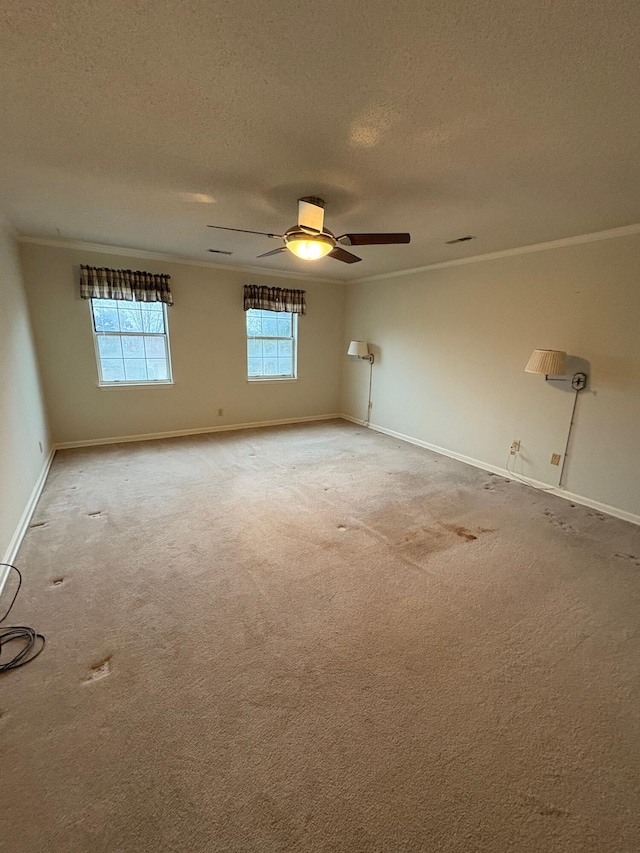 carpeted empty room featuring a textured ceiling, ceiling fan, and crown molding