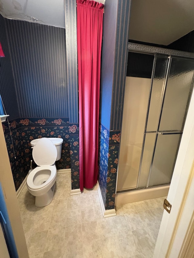 bathroom with toilet and a shower with shower door