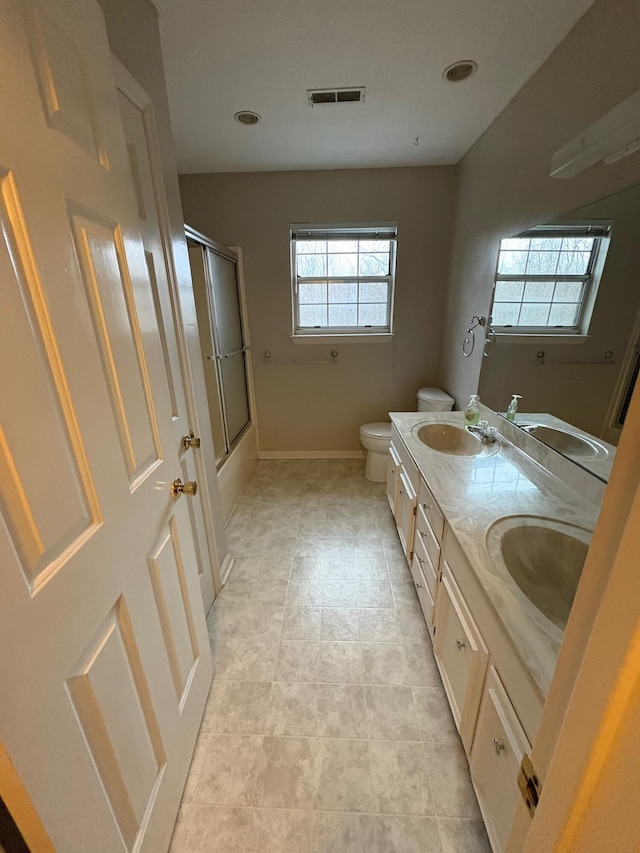 full bathroom with vanity, toilet, and combined bath / shower with glass door