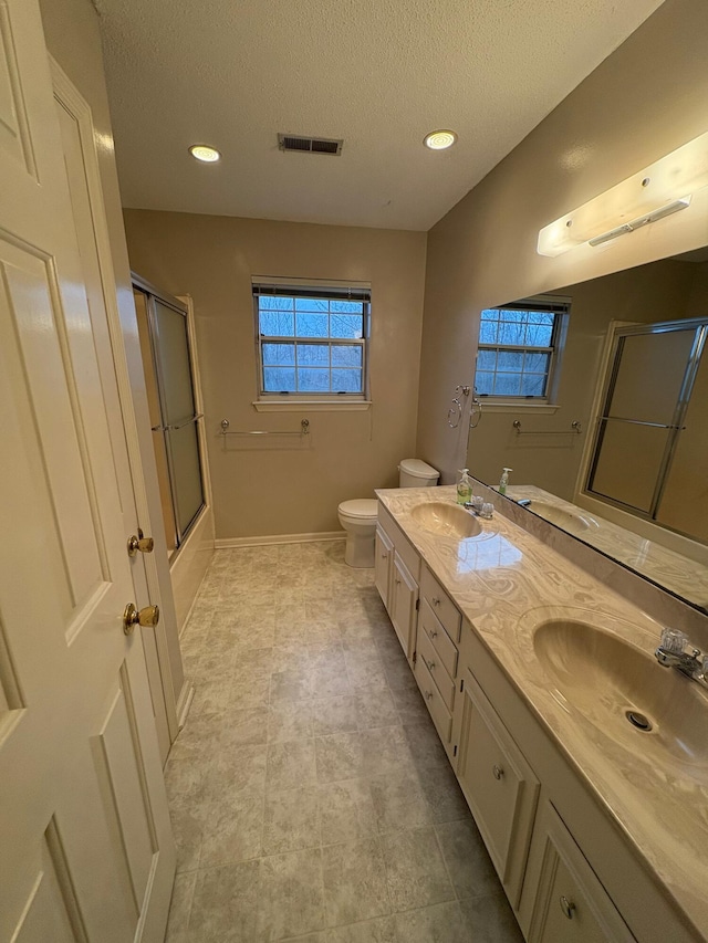 full bathroom with vanity, toilet, shower / bath combination with glass door, and a textured ceiling