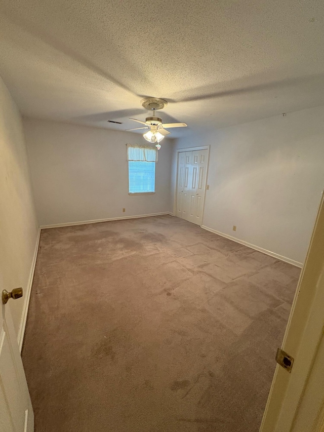 carpeted empty room with a textured ceiling and ceiling fan