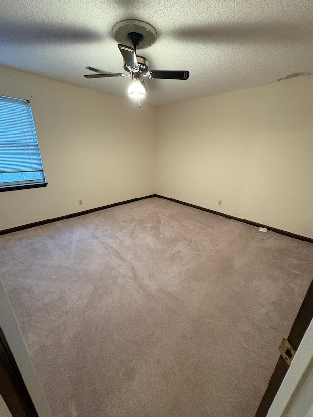 empty room featuring light carpet, ceiling fan, and a textured ceiling