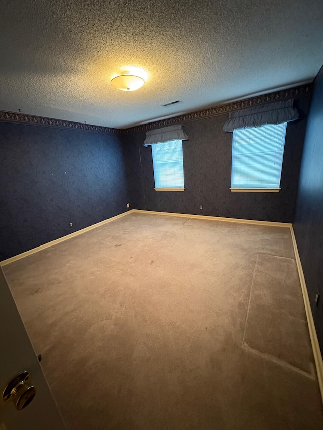 empty room with a textured ceiling and carpet floors