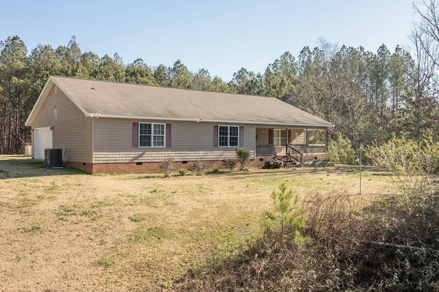 ranch-style house featuring central air condition unit, covered porch, a front yard, and a garage