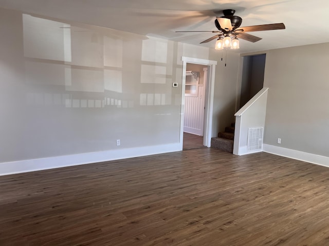 spare room with dark wood-type flooring and ceiling fan