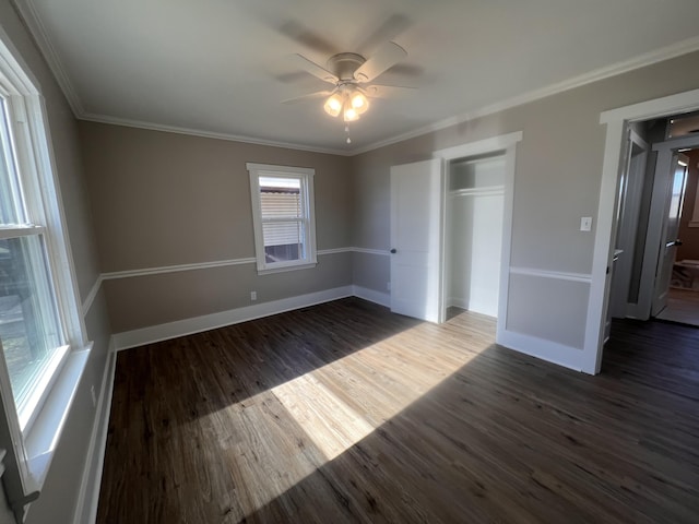 unfurnished bedroom with ceiling fan, ornamental molding, dark hardwood / wood-style flooring, and a closet