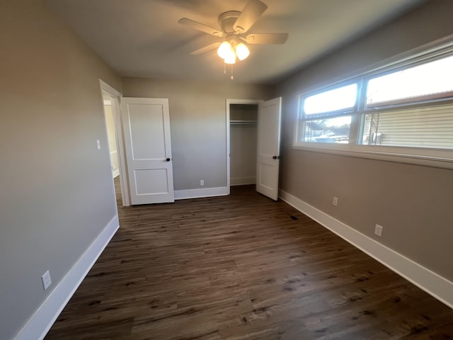 unfurnished bedroom with a closet, dark hardwood / wood-style floors, and ceiling fan