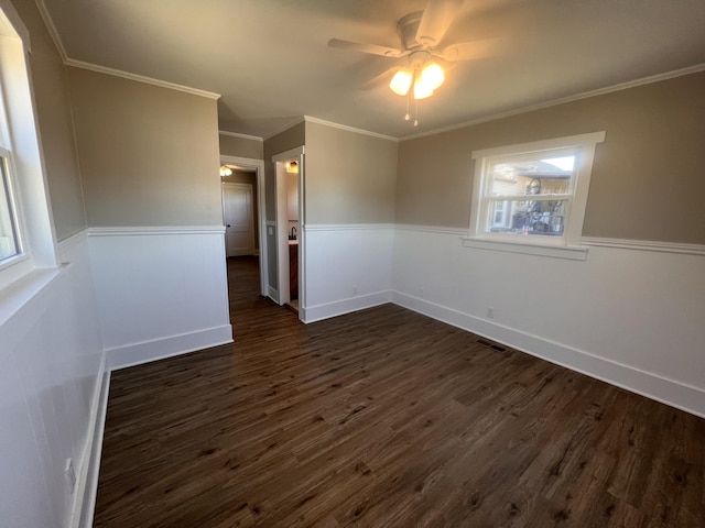 unfurnished room with crown molding, dark hardwood / wood-style floors, and ceiling fan