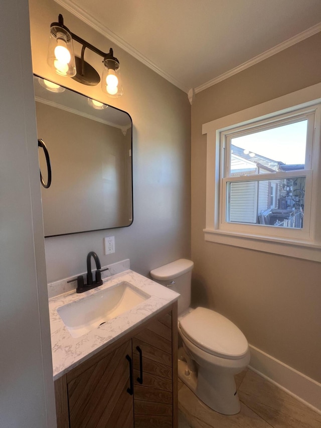 bathroom with crown molding, vanity, and toilet