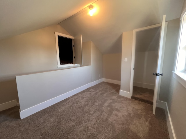 bonus room with vaulted ceiling and carpet