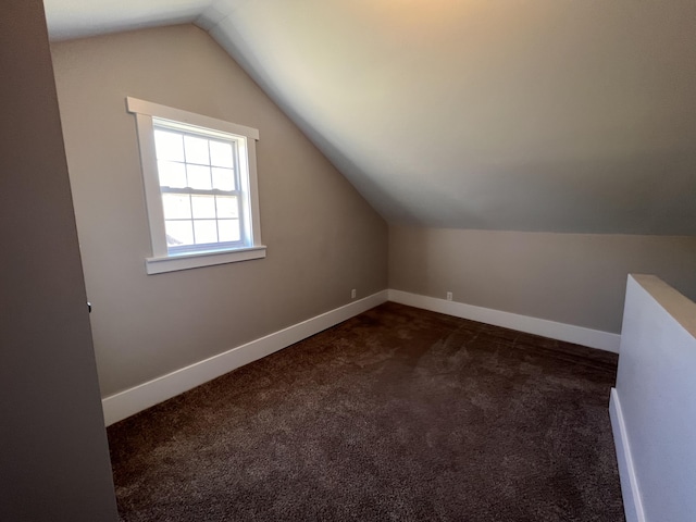 bonus room featuring vaulted ceiling and dark colored carpet