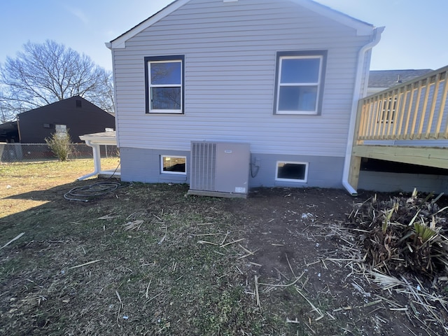 view of side of home with central AC unit and a wooden deck