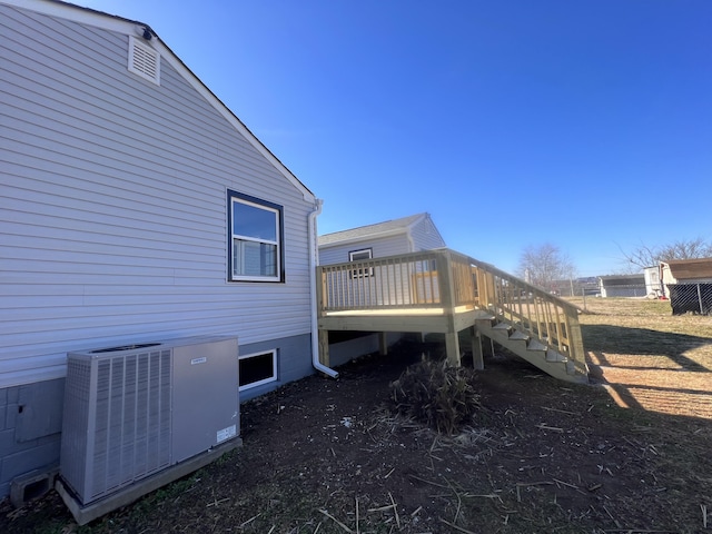 view of side of property with cooling unit and a deck