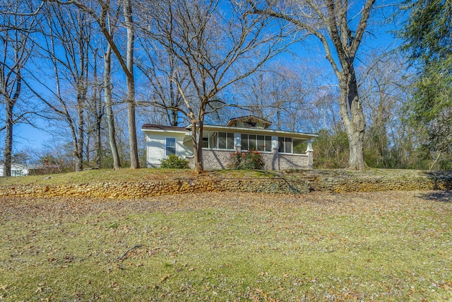 ranch-style house with a front lawn and a sunroom