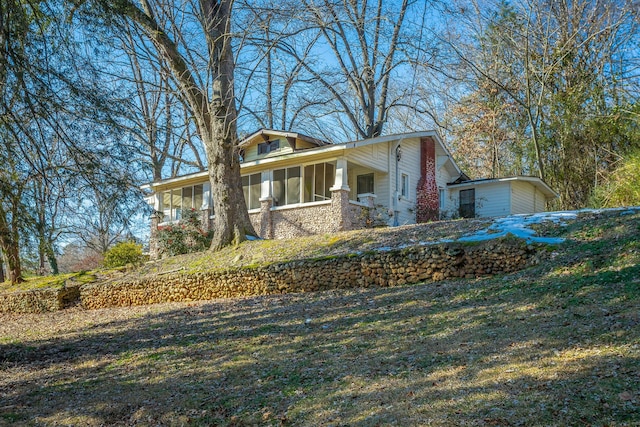 view of front facade with a front lawn and a sunroom