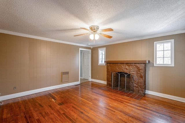 unfurnished living room with plenty of natural light, ornamental molding, and hardwood / wood-style floors