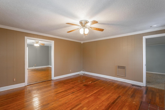 empty room featuring ceiling fan, a textured ceiling, ornamental molding, and hardwood / wood-style floors