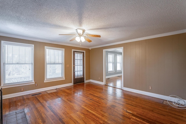 empty room featuring crown molding and plenty of natural light