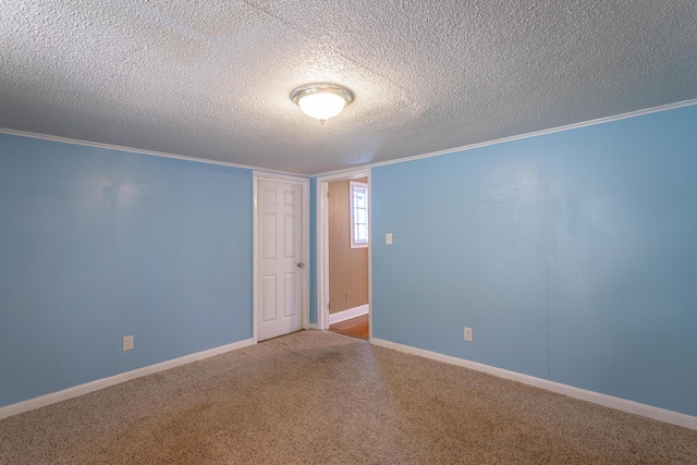 carpeted empty room featuring crown molding and a textured ceiling