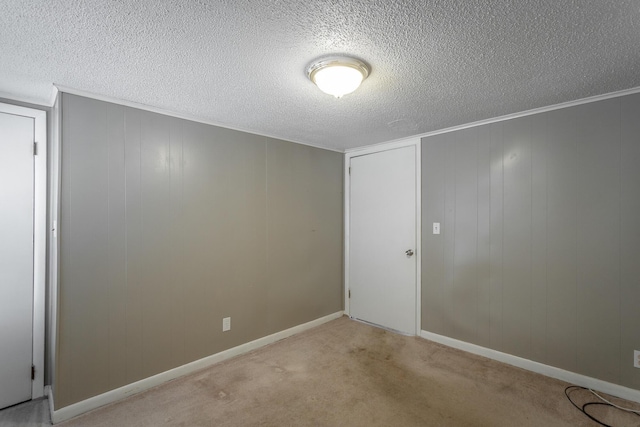 carpeted empty room featuring a textured ceiling and crown molding