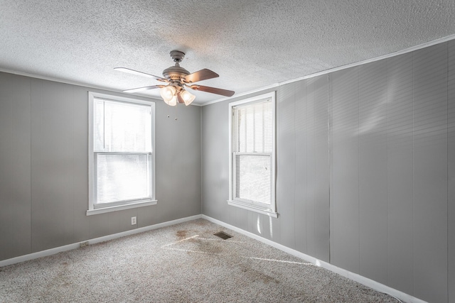 unfurnished room featuring ceiling fan, ornamental molding, and carpet flooring