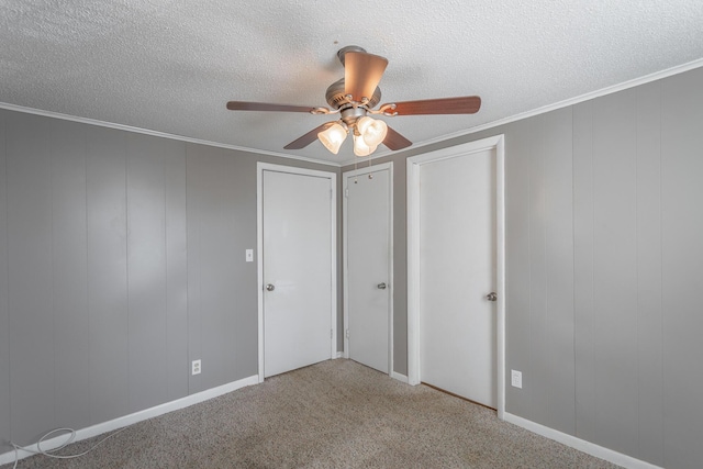 unfurnished bedroom featuring ceiling fan, carpet, crown molding, and a textured ceiling