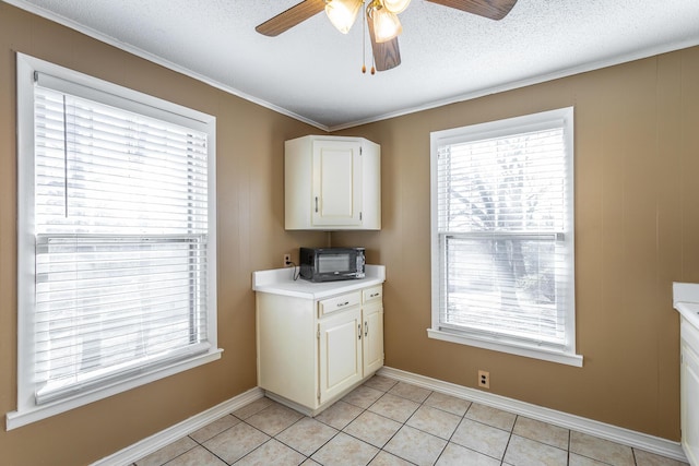 kitchen with a textured ceiling, ceiling fan, light tile patterned floors, and white cabinetry