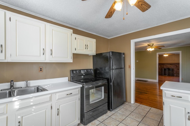 kitchen with ceiling fan, black appliances, sink, light tile patterned flooring, and white cabinetry