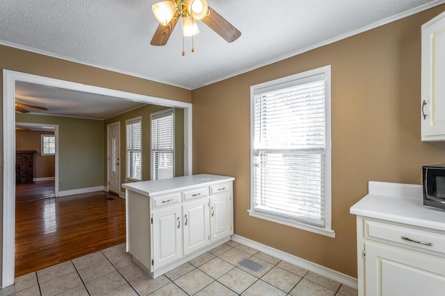 kitchen featuring white cabinetry, light tile patterned floors, kitchen peninsula, and a textured ceiling