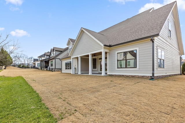 back of house with a lawn and a porch