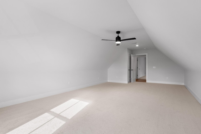 additional living space with ceiling fan, light colored carpet, and vaulted ceiling