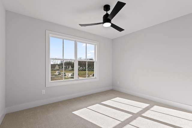 carpeted spare room featuring ceiling fan