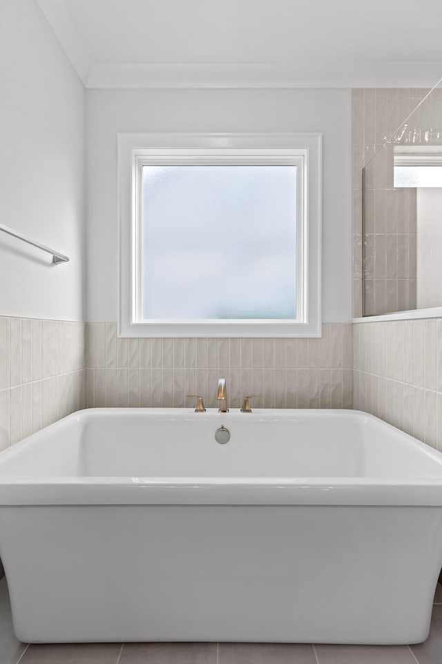 bathroom featuring a bath and crown molding