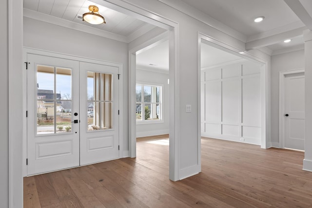 entryway featuring french doors, light wood-type flooring, and crown molding