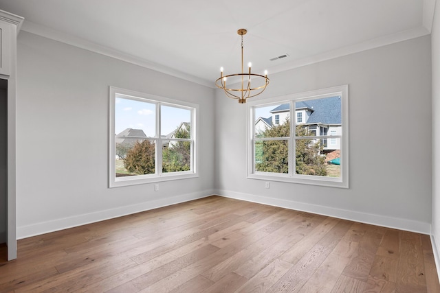 unfurnished dining area with hardwood / wood-style flooring, an inviting chandelier, and crown molding