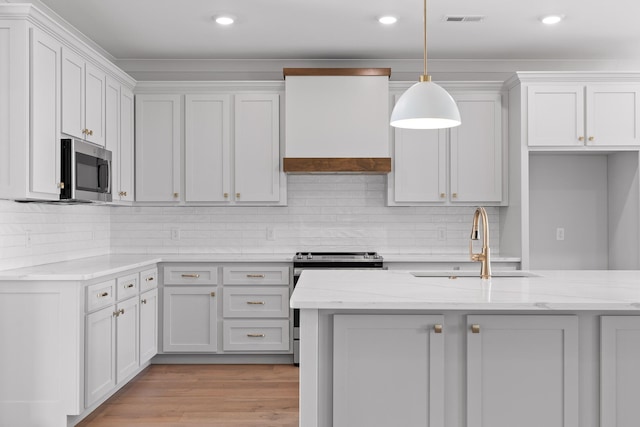 kitchen featuring white cabinetry, light stone counters, and pendant lighting