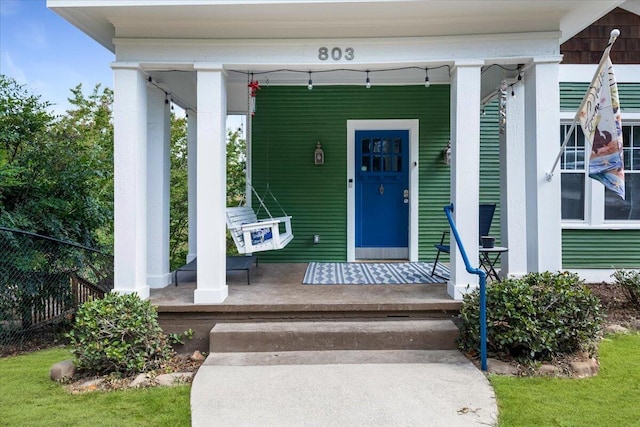 view of exterior entry featuring covered porch