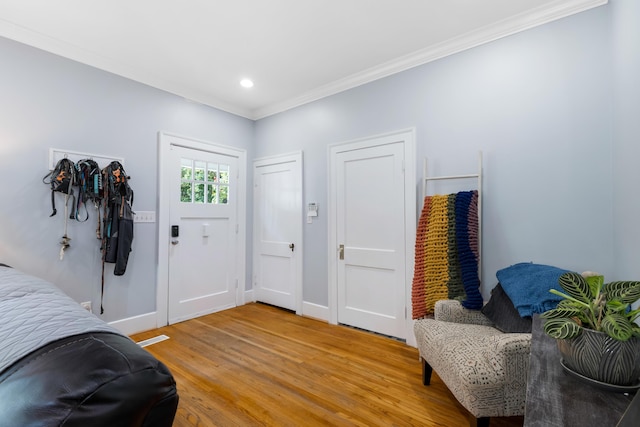 foyer entrance featuring hardwood / wood-style flooring and crown molding