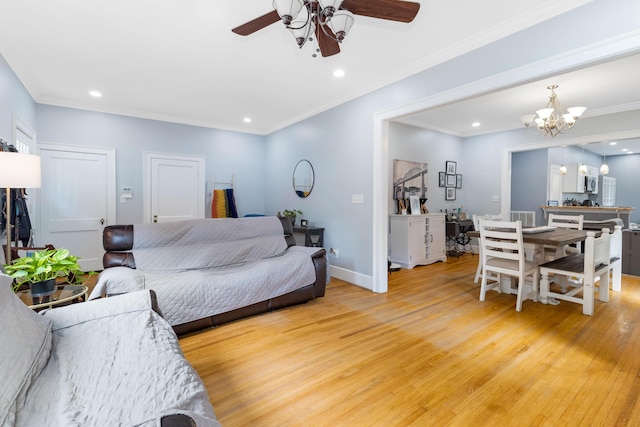 living room featuring crown molding, wood-type flooring, and ceiling fan with notable chandelier