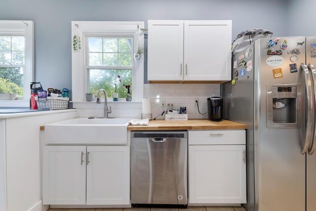 kitchen with white cabinets, appliances with stainless steel finishes, wooden counters, and sink