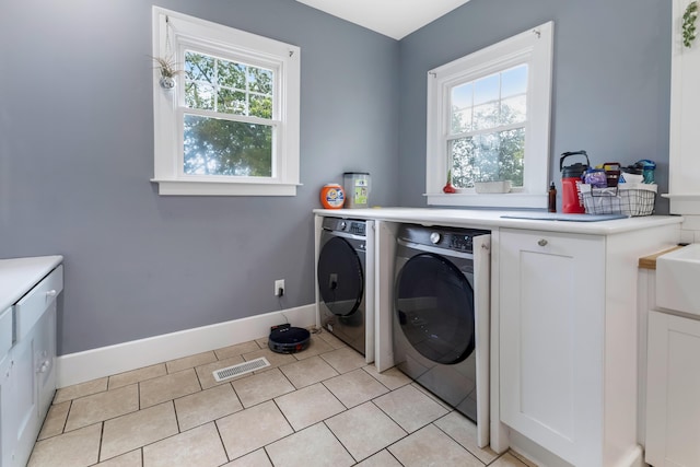 laundry room featuring washing machine and clothes dryer and light tile patterned floors