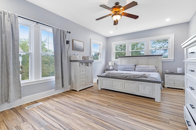 bedroom featuring multiple windows, ceiling fan, and light wood-type flooring