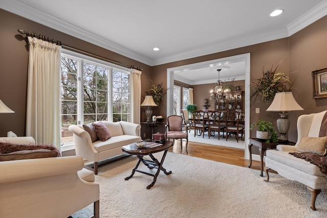 living room featuring hardwood / wood-style floors, a notable chandelier, and crown molding