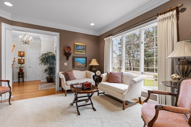 living room with ornamental molding, light hardwood / wood-style flooring, and an inviting chandelier