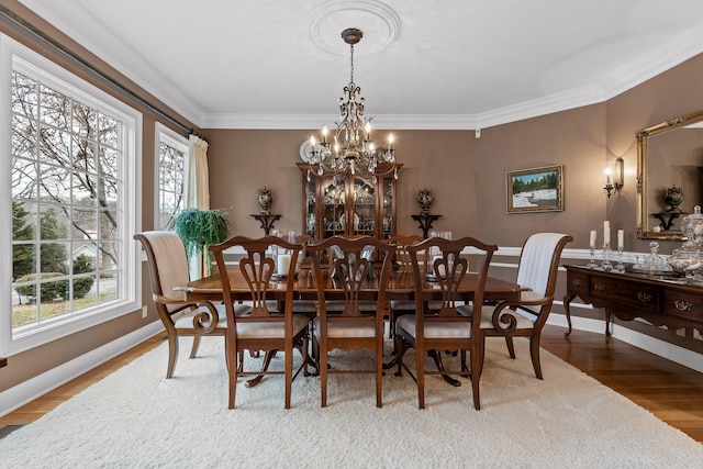 dining area featuring a chandelier, a wealth of natural light, and crown molding