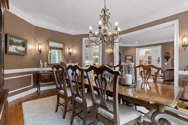 dining space featuring an inviting chandelier, dark hardwood / wood-style floors, and ornamental molding