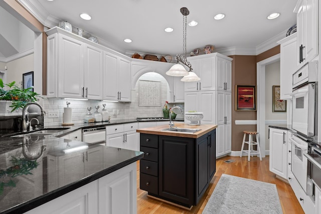 kitchen with sink, white cabinets, and pendant lighting