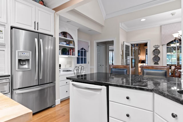 kitchen with ornamental molding, dark stone counters, white cabinets, stainless steel fridge with ice dispenser, and light hardwood / wood-style floors