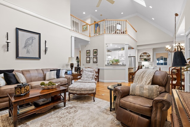 living room with crown molding, built in features, high vaulted ceiling, and light hardwood / wood-style flooring